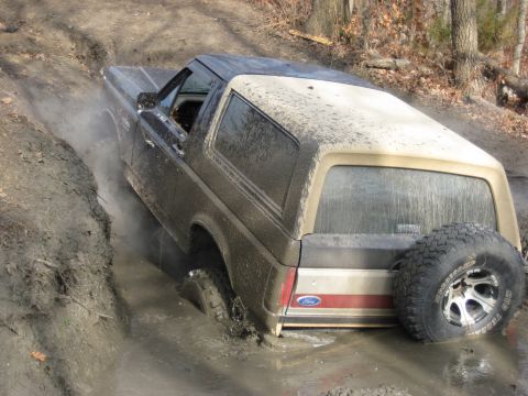 2005 Jeep Wrangler - This Ford Bronco is deep in mud while navigating an off-road trail.