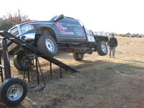 2005 Jeep Wrangler - A black 2005 Dodge Ram pickup truck is positioned on a metal ramp, with one front wheel elevated.
