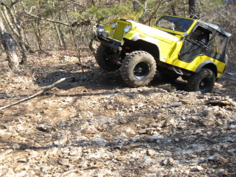 2005 Jeep Wrangler - Yellow Jeep CJ-7 tackling a challenging rocky off-road course.