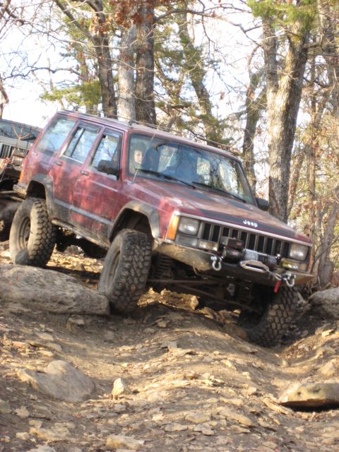2005 Jeep Wrangler - A red Jeep Cherokee XJ navigates a rocky off-road trail, demonstrating its capability on-trail capabilities.