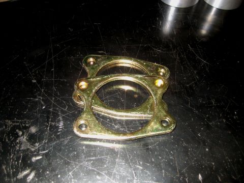 1996 Ford Bronco - Close-up of two exhaust gaskets on a black, textured surface.
