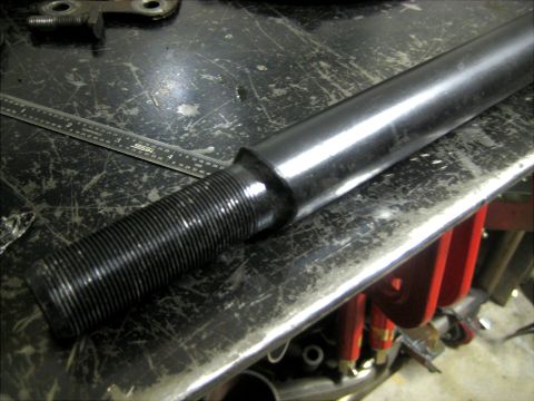 1996 Ford Bronco - A close-up shows a threaded metal rod with a ruler nearby on a scratched workbench surface.