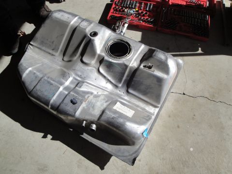 1995 Ford Taurus - Fuel tank and fuel pump assembly removed from a vehicle, with tools nearby.