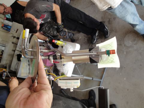 1995 Ford Taurus - A person holds a disassembled fuel pump assembly, likely for a vehicle repair.