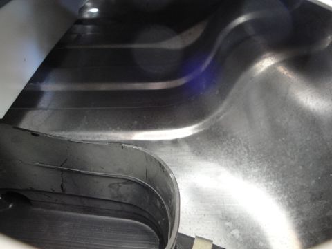 1995 Ford Taurus - The interior of a car trunk shows ribbed metal panels and black plastic trim pieces.