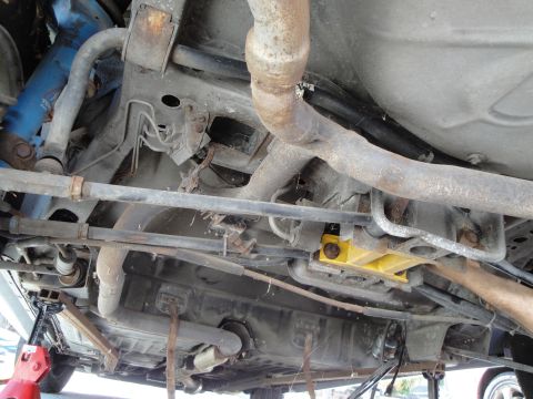 1995 Ford Taurus - The undercarriage of a vehicle is shown, revealing its exhaust system, fuel tank, and suspension.