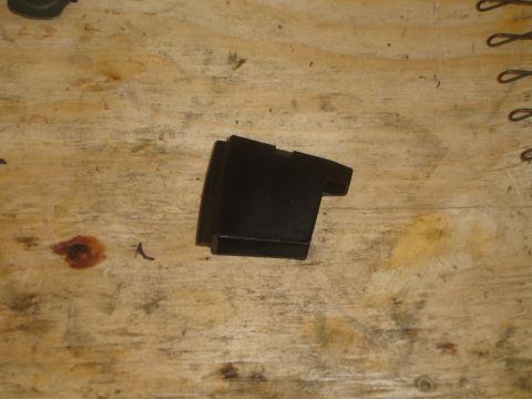 1989 Ford Bronco - A black plastic automotive part is shown on a wooden workbench.