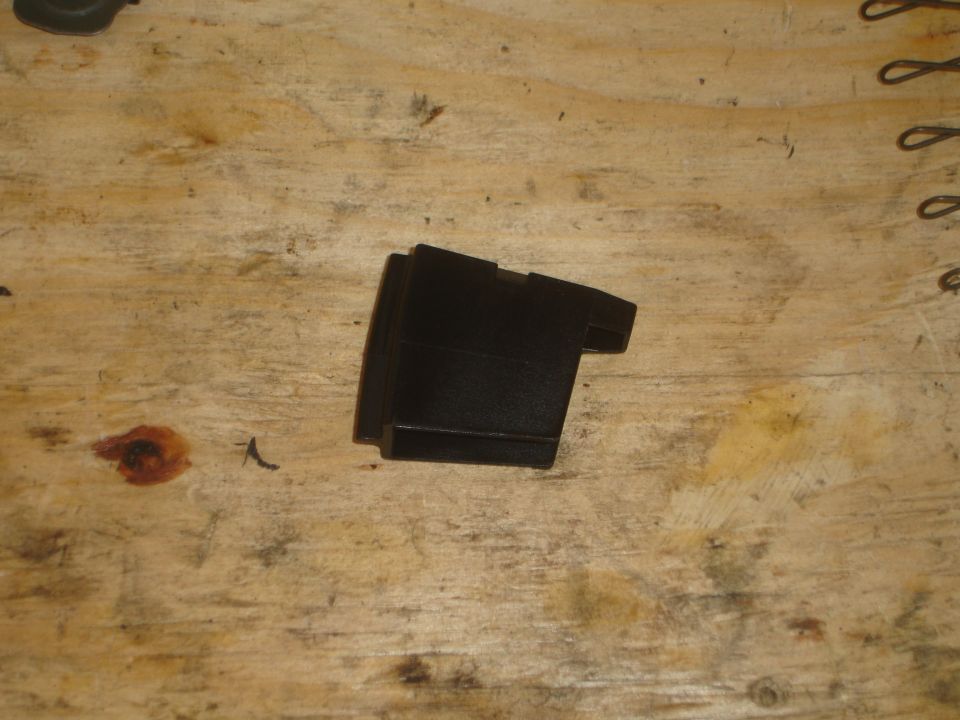 Black plastic automotive part on a wooden surface