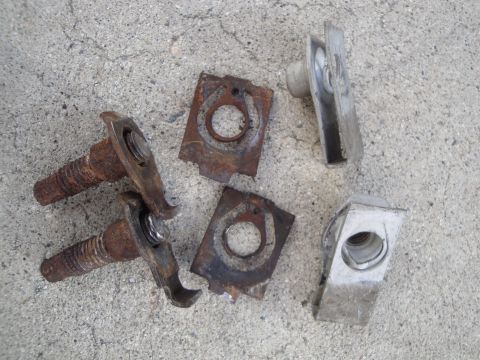 1995 Ford Taurus - A collection of old, rusted metal fasteners and clips are scattered on a concrete surface.
