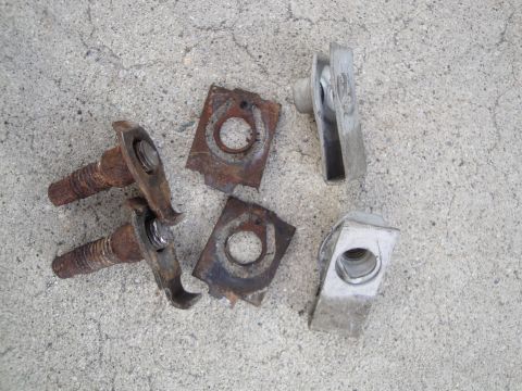 1995 Ford Taurus - A collection of old, rusty automotive fasteners and metal clips are scattered on a textured concrete background.