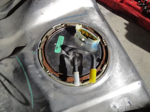 1995 Ford Taurus - Fuel pump assembly removed from a metal tank, showing a green Ford sticker with part numbers.