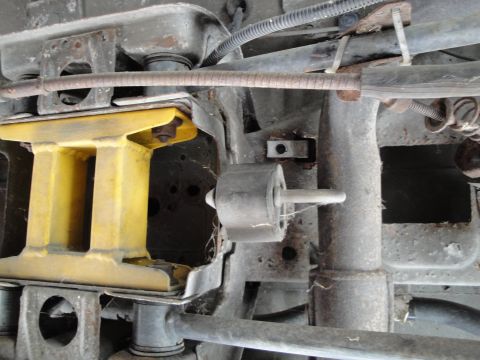 1995 Ford Taurus - Close-up view of the undercarriage, showing a yellow suspension brace and a rubber mount.