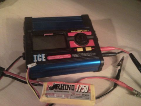 1989 Ford Bronco - RC battery charger and battery pack shown on a surface.
