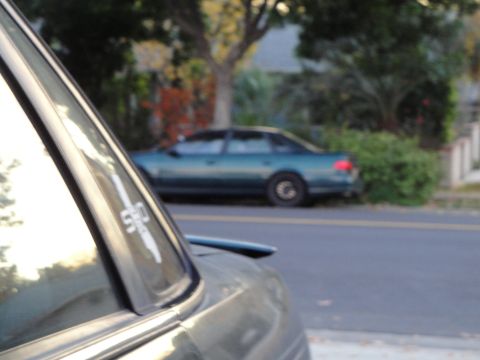 1995 Ford Taurus - Side view of a green sedan parked on a residential street.