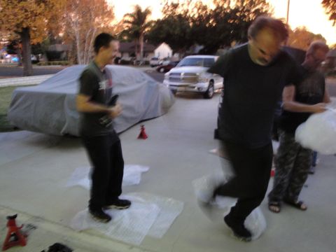 1995 Ford Taurus - A car is covered by a gray tarp in a driveway.