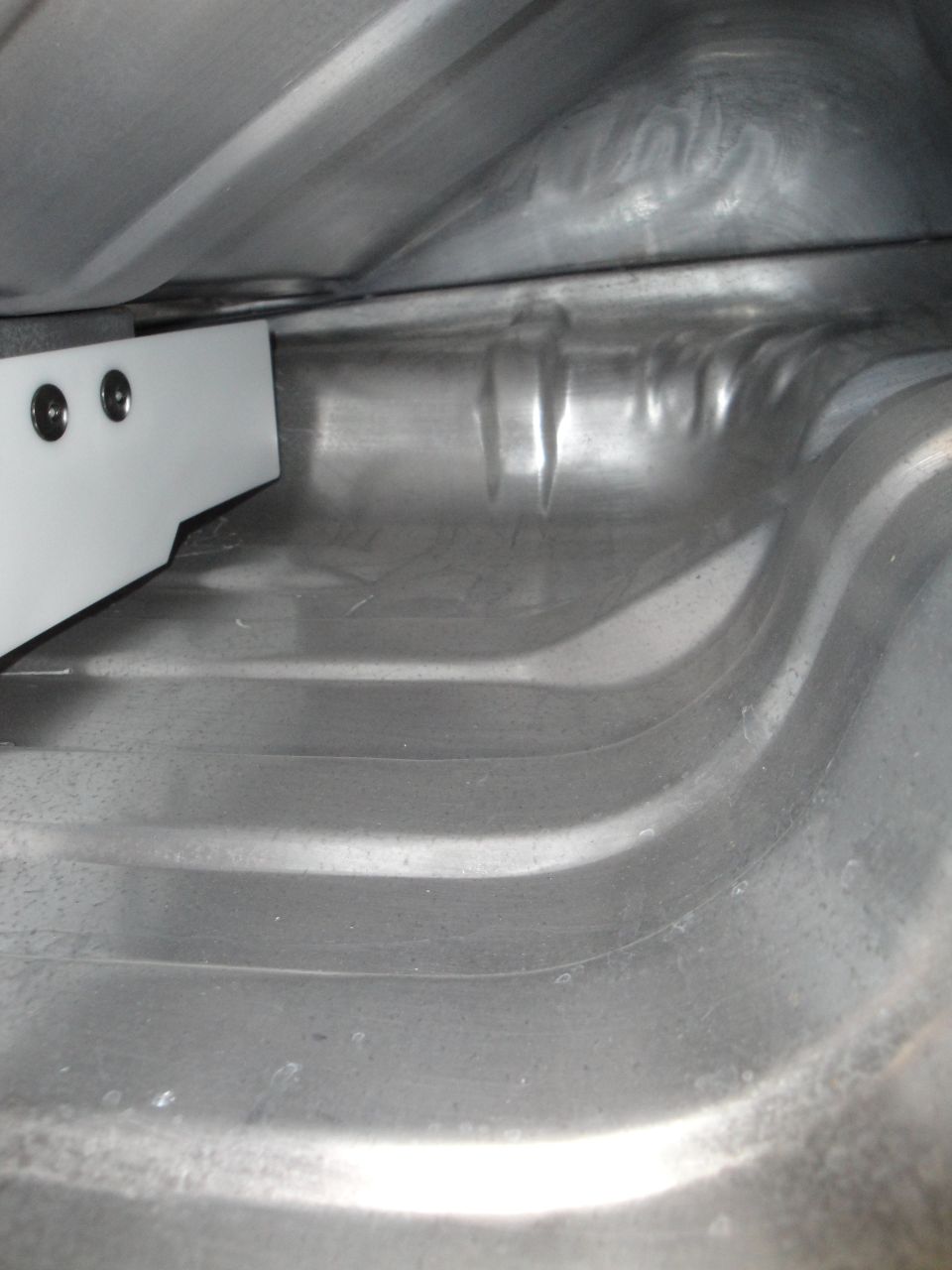 Interior of a car's trunk with a white bracket attached to the left side