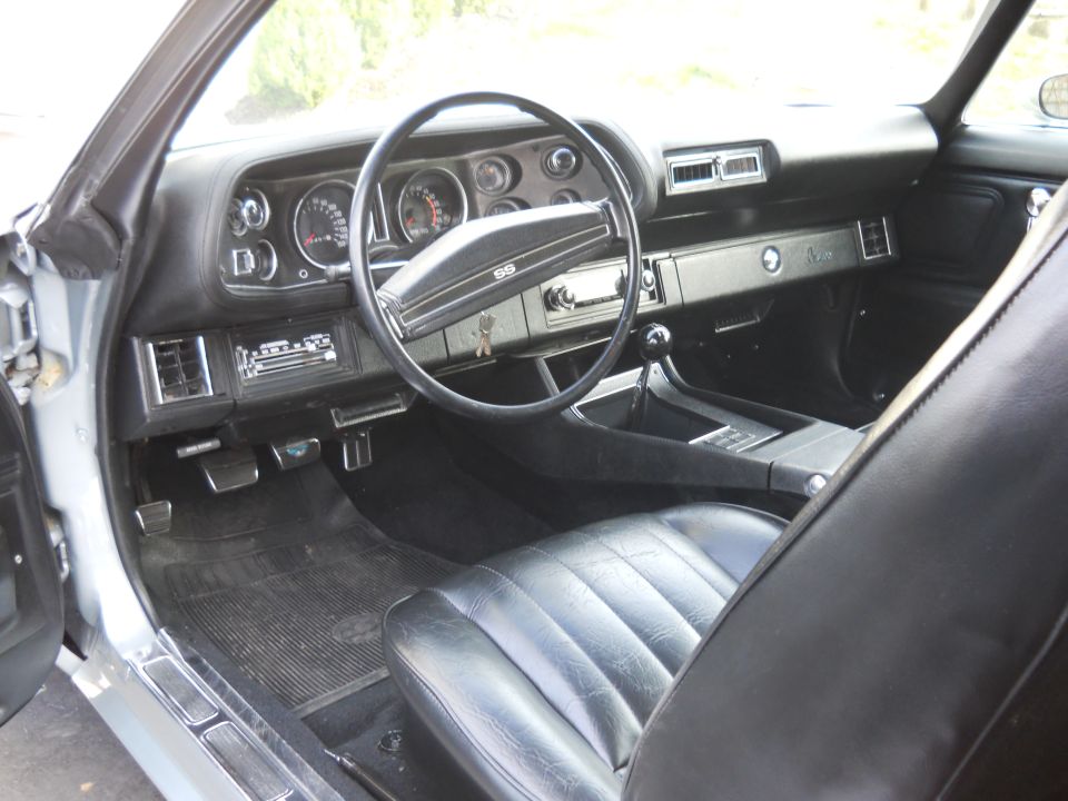 Black leather interior of a 1970 Chevrolet Camaro SS with a dashboard, steering wheel, and center console visible