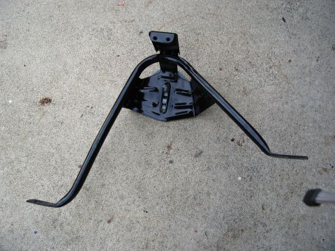 1986 Ford Bronco - This is a tire carrier bracket, likely for a vehicle, shown on a concrete surface.