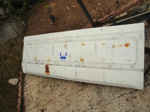 1986 Ford Bronco - Tailgate panel with rust and a dog sticker, likely from an older vehicle.