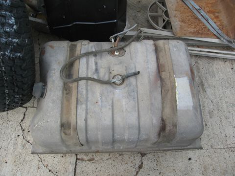 1986 Ford Bronco - A metal gas tank with attached fuel lines and straps, likely a replacement part.