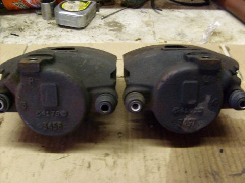 1986 Ford Bronco - A pair of used brake calipers are shown, with some part numbers visible on their surfaces.