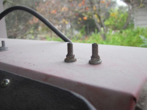 1979 Ford Bronco - Close-up of two rusty bolts on a surface, with a blurred outdoor background.