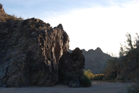 1982 Ford Bronco - A wide shot captures a desert scene with large rock formations and sparse vegetation under a clear sky.