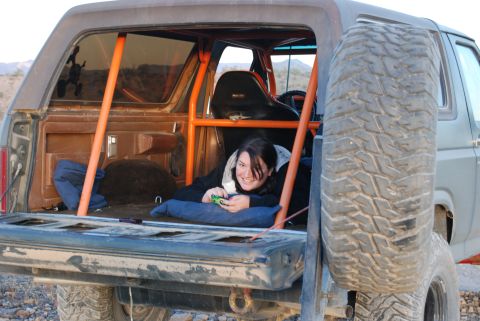 1982 Ford Bronco - A woman relaxes inside a heavily modified Ford Bronco, which appears to be from the early 1980s.