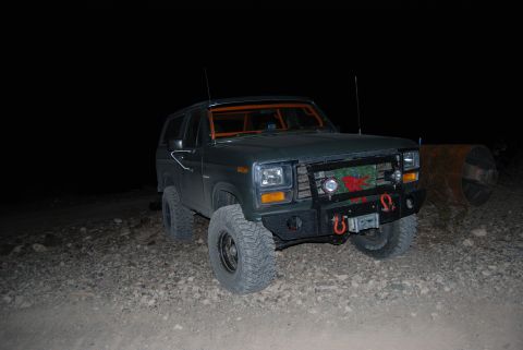 1982 Ford Bronco - A modified Ford Bronco sits on a rocky surface under the night sky.
