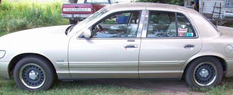 2000 Mercury Grand Marquis - Side profile of a 2000 Mercury Grand Marquis sedan parked outdoors.