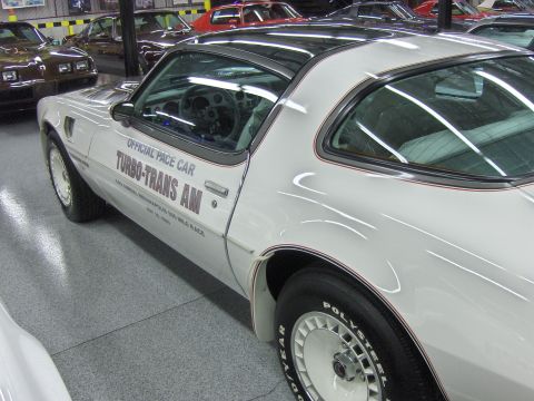 1982 Chevrolet Camaro - This white 1980 Pontiac Turbo Trans Am Pace Car is displayed indoors with other vehicles visible vehicles in-line vehicles.