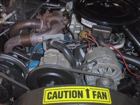 1982 Chevrolet Camaro - Close-up view of an engine bay, showing various components and a warning label.