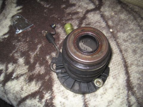 2003 Ford Ranger - A clutch release bearing is shown resting on a patterned cloth, with a small plastic bag of parts nearby.