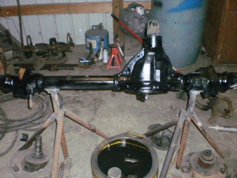 1995 Ford Bronco - A differential axle assembly is shown disassembled and supported by stands in a workshop.