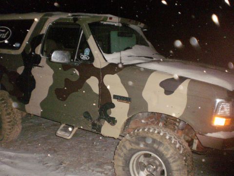 1995 Ford Bronco - Camouflaged 1995 Ford Bronco in snowy conditions at night.