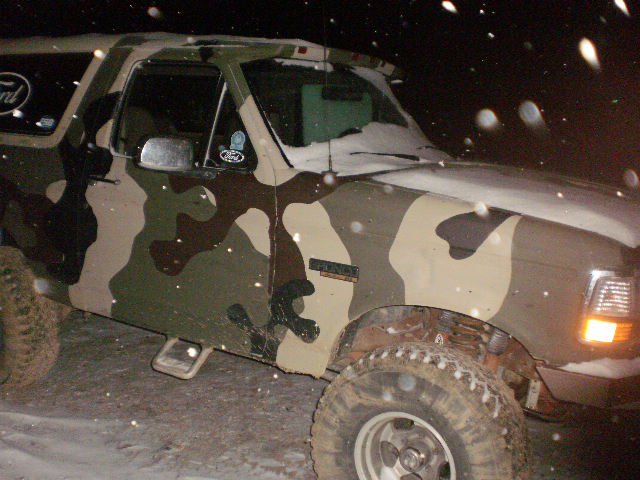 1995 Ford Bronco in camouflage paint, parked in snow