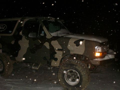 1995 Ford Bronco - A camouflaged Ford Bronco is seen in a snowy environment during nighttime.