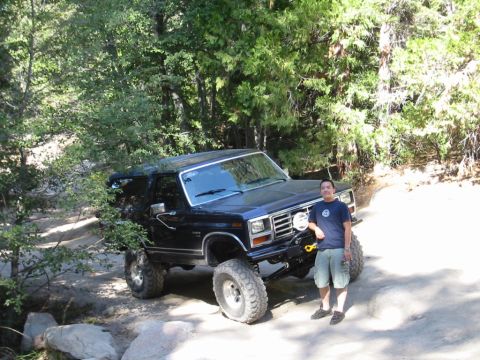 1985 Ford Bronco - A man poses with his modified Ford Bronco off-road.
