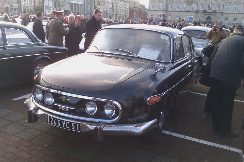 Black sedan with a chrome grille and triple headlights, parked outdoors