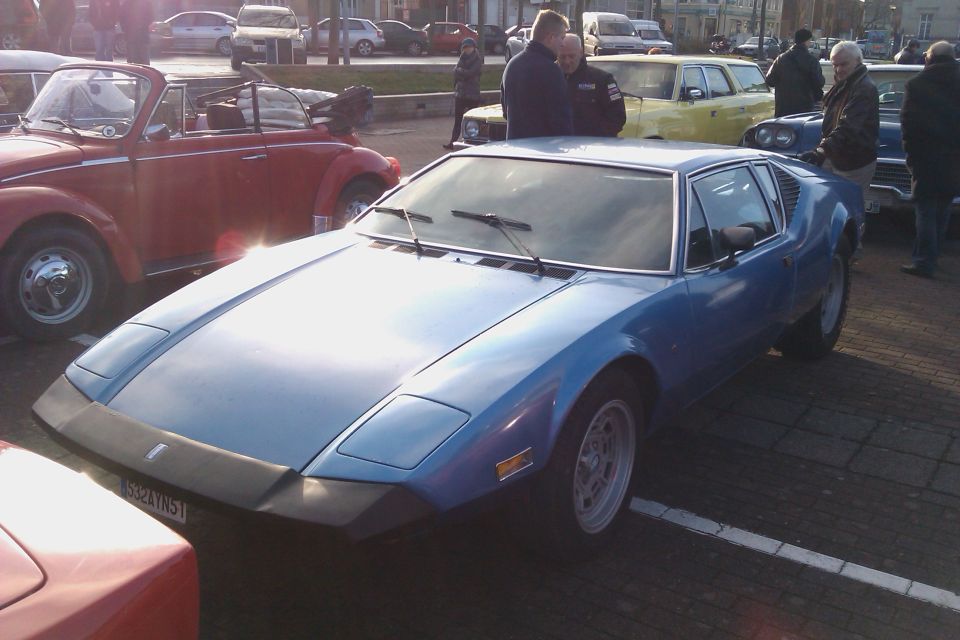 Blue sports car parked next to a red convertible and other vehicles