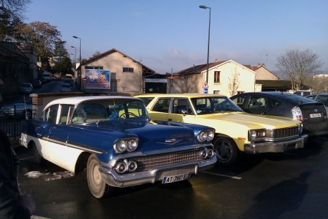 1991 Ford LTD Crown Victoria - Two classic cars, a blue and white 1958 Chevrolet Bel Air and a yellow sedan, are parked outdoors.