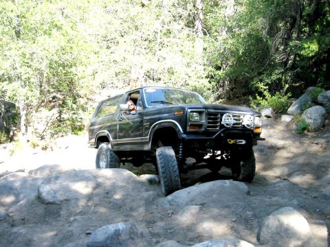 1985 Ford Bronco - This 1985 Ford Bronco is shown off-roading over a challenging rocky path.
