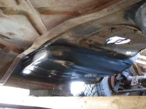 1977 Ford F-150 - Underside view of a vehicle's fuel tank and frame. A tire is visible on the right.