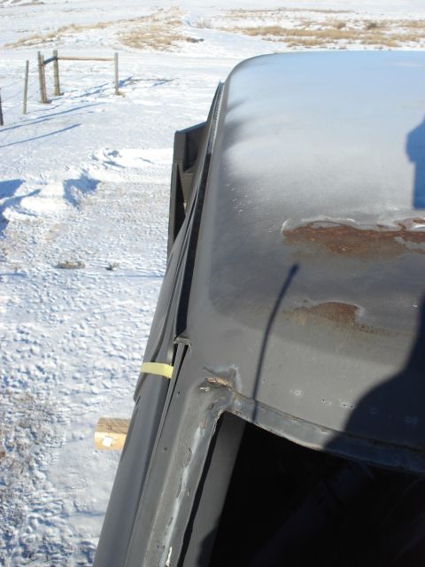 1977 Ford F-150 - Close view of the roofline of a truck, showing some rust and a yellow tape marker.