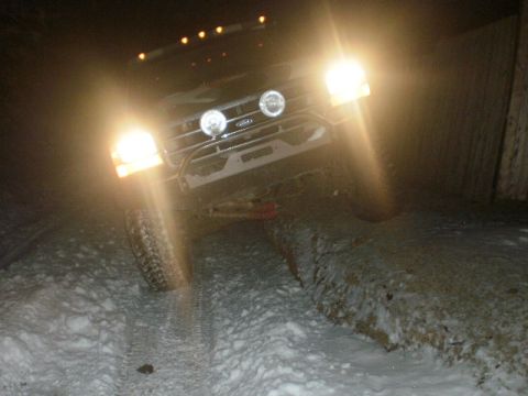 1995 Ford Bronco - This 1995 Ford Bronco navigates a snowy path at night, its headlights cutting through the darkness.