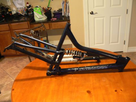 1978 Ford Bronco - A blue Santa Cruz bicycle frame with a rear shock absorber is displayed on a table.