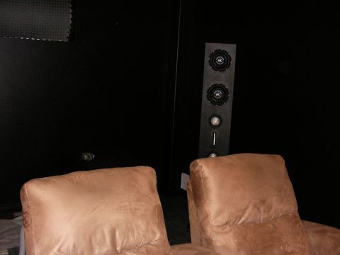 1987 Ford Bronco - A view inside a room shows two comfortable brown chairs positioned in front of a black wall with a tall speaker system.