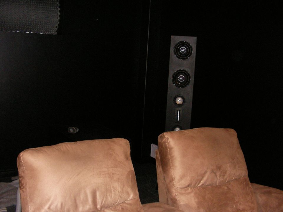 Interior scene with two brown chairs and a vertical speaker system