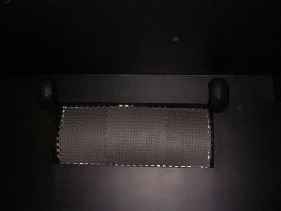 Close-up of a textured mat with two black handles on a dark surface