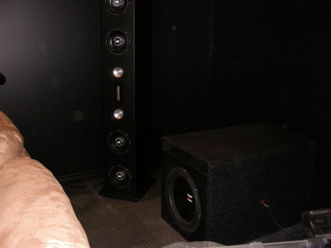 1987 Ford Bronco - The interior of a vehicle is shown, a tall speaker array and a subwoofer box, with a watermark from Supermotors.net.